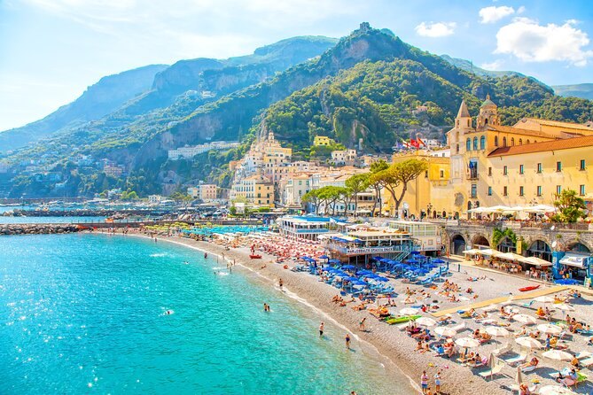 Amalfi town and its beach from the water, with the shallows turning turquoise inshore
