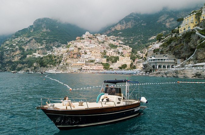 A boat lying at a mooring buoy below the cliffs of the Amalfi Coast