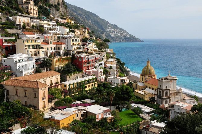 A coastal town on a green slope with its gardens terraced down towards the sea