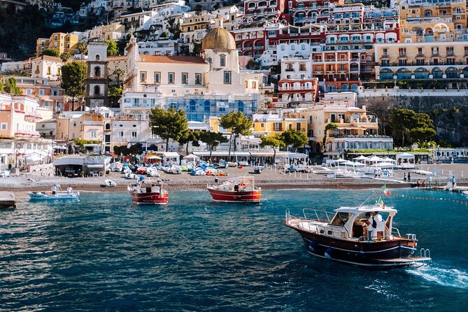 Positano's stacked houses and the dome of its parish church seen from a boat offshore